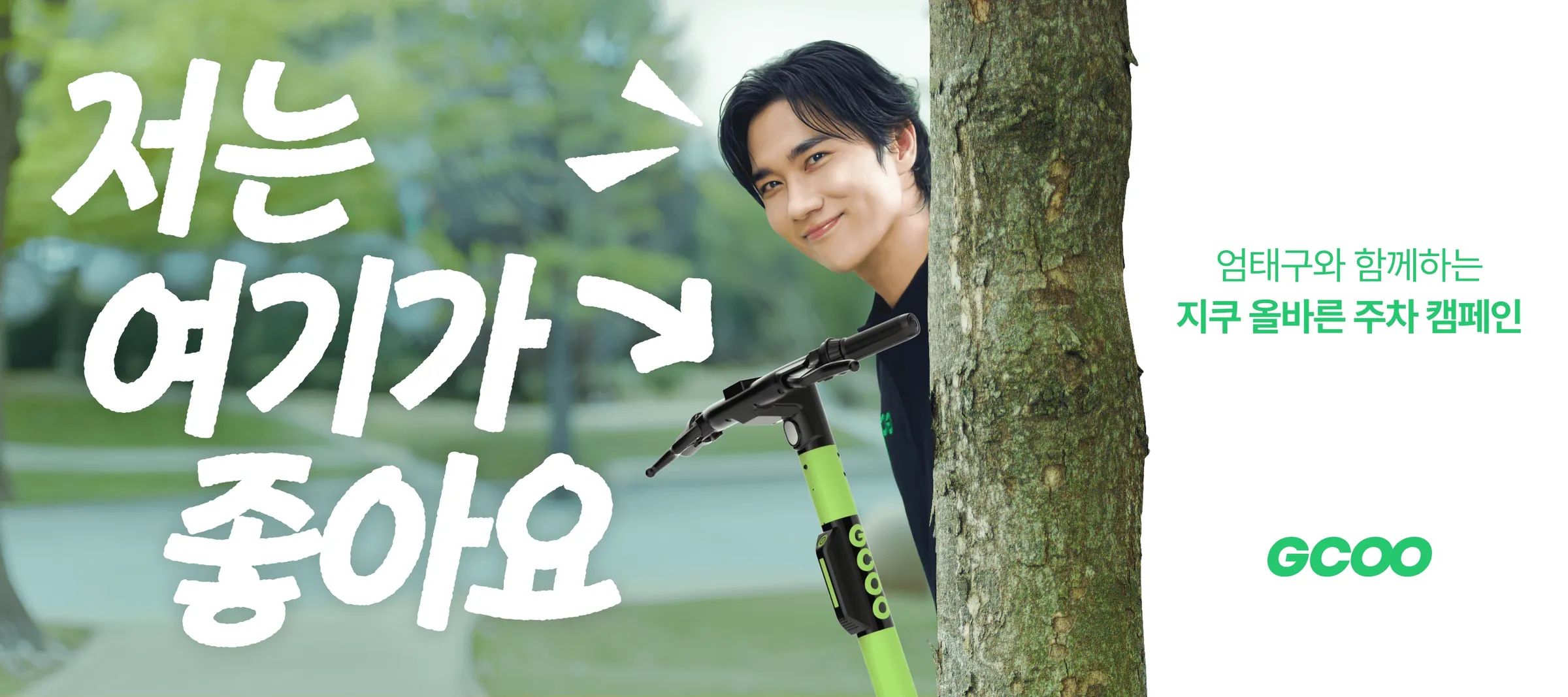 Um Tae-goo peeking out from behind a tree with a GCOO scooter, key visual ‘I like it here’