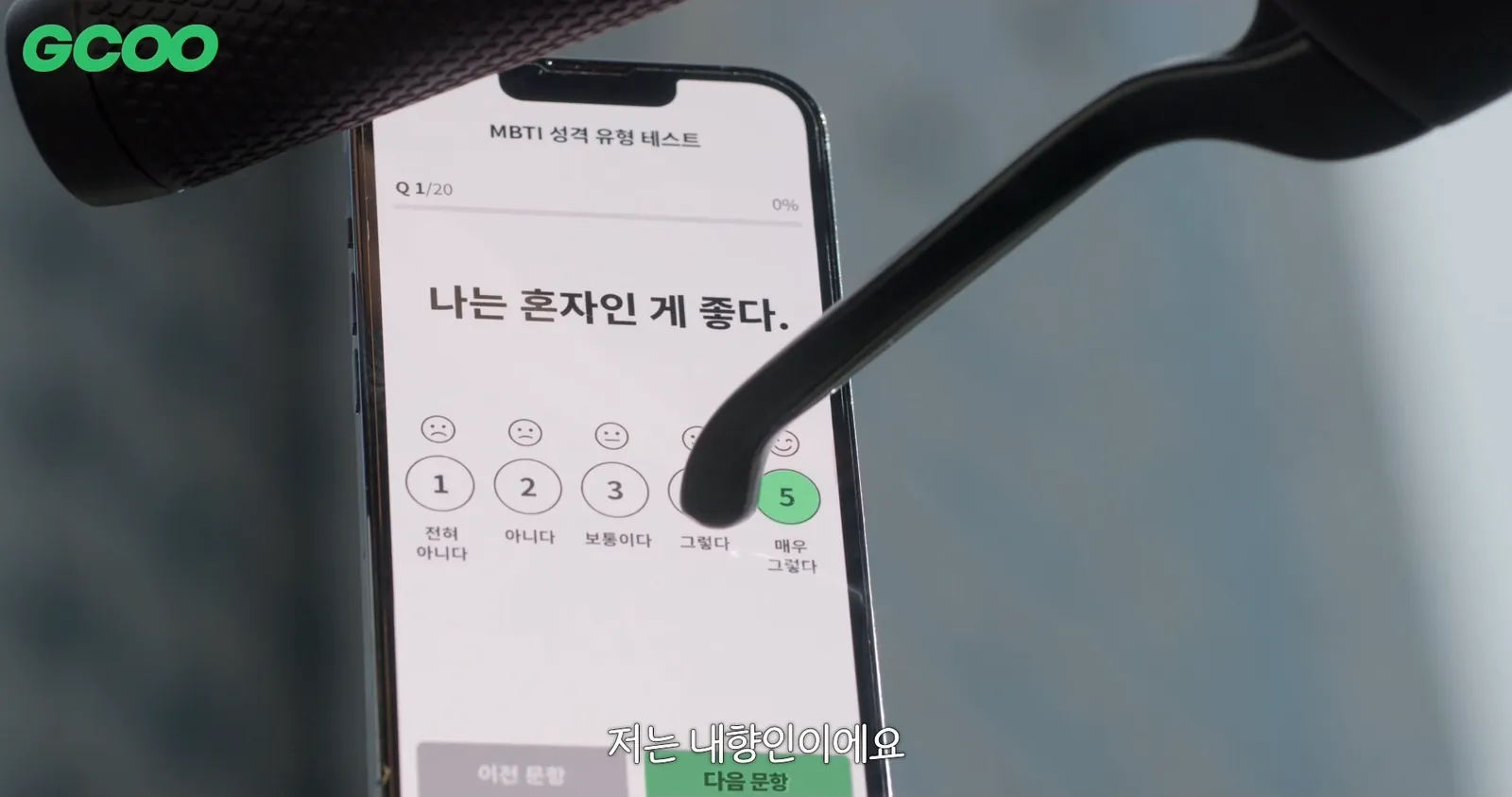 A personality test on a phone beside GCOO handlebars, with ‘Strongly agree’ selected for ‘I like being alone’